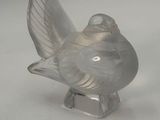 a glass bird that is sitting on top of a table