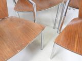 four wooden chairs sitting next to each other in a room