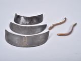 four pieces of metal on a white surface with a wooden handle