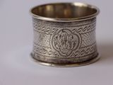 une vieille serviette en argent, ornée d'un monogramme sur fond blanc