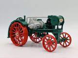 a green and red model of a tractor on a white surface