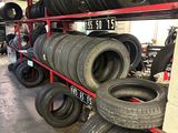 tires are stacked on a rack in a tire shop