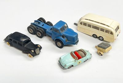 cinq petites voitures et un bus posés sur une surface blanche