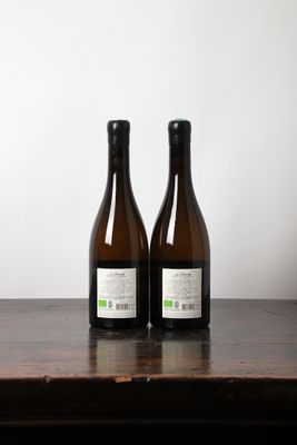deux bouteilles de vin posées sur une table l'une à côté de l'autre