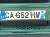 a close up of a license plate on the back of a green truck