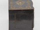 a black wooden box with a gold decoration on the top