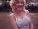 une femme, une fleur à la bouche, posant pour une photo