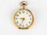 a gold pocket watch with a white face on a white surface