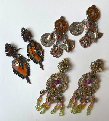 five pairs of earrings and a broochet on a table