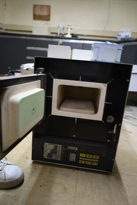a person standing next to an open oven in a room