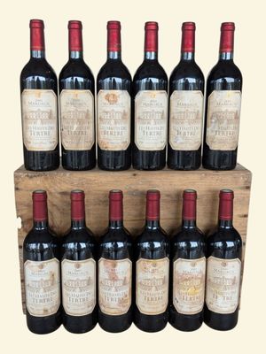 six bottles of red wine are lined up on a wooden shelf