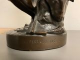 a bronze statue of a man with a dog on his lap