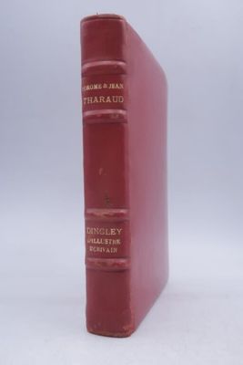 an old red book sitting on top of a white surface