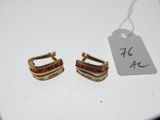 deux paires de boucles d'oreilles en or avec une étiquette sur un fond blanc