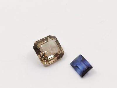 a close up of two different colored gems on a white surface