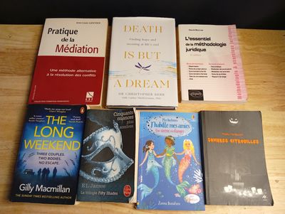 plusieurs livres posés sur une table en bois, avec une chaise noire en arrière-plan