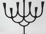 an image of a black iron candelier with five candles