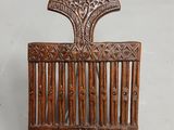 une image représentant un peigne en bois orné d'un motif décoratif sur le dessus