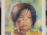 painting of a young girl in a yellow shirt in a white frame