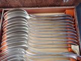 a lot of silver spoons in a box on the table