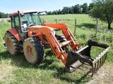 a tractor that is sitting in the grass in the field