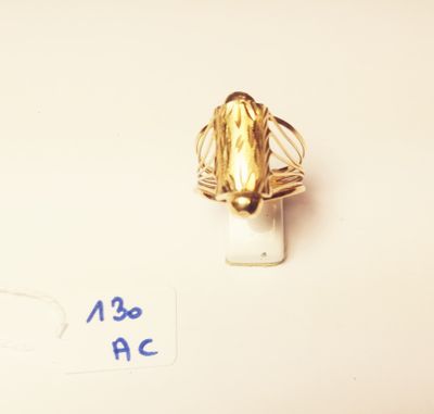 a gold ring with a leaf on it on a white surface