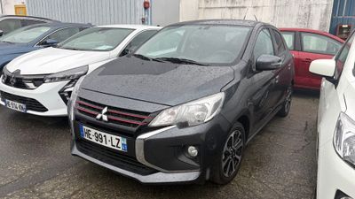 Plusieurs voitures sont garées sur un parking situé devant un immeuble.