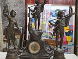 une statue en bronze représentant un homme et une femme, avec une horloge