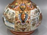 a vase with a painting on it sitting on a table