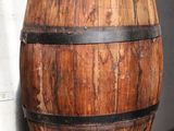 un tonneau en bois posé sur une étagère en verre près d'un mur