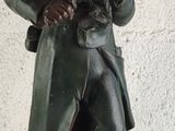statue of a man holding a rifle and a flag on a table