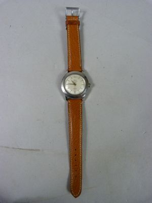 une image d'une montre sur une surface blanche avec un bracelet marron