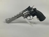 a close up of a revolver on a clear stand on a white surface