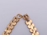 a close up of a gold bracelet with a chain attached to it