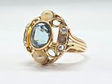 une image représentant une bague en or sertie d'une topaze bleue et de perles