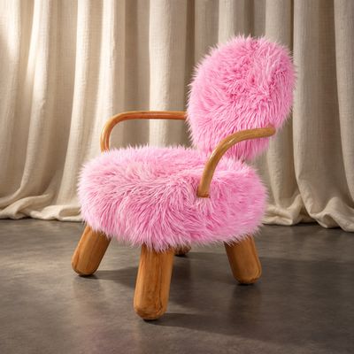 une chaise rose avec une structure en bois et une assise recouverte de fourrure rose