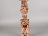 une vieille statue en bois représentant une femme coiffée d'un chapeau