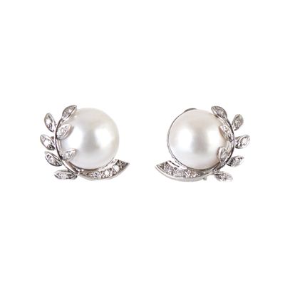 paire de boucles d'oreilles en perles et diamants sur fond blanc
