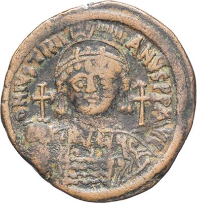 une pièce de monnaie ancienne sur laquelle figurent le buste d'une femme et une croix