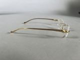 pair of glasses on a white surface with a black object in the background