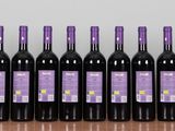 six bottles of wine are lined up on a wooden table