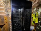 a wine cooler in a room with a lot of bottles