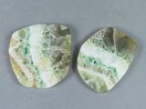 deux morceaux de marbre vert et blanc posés sur une surface grise