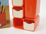 an orange and white desk organizer next to a book