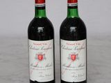 two bottles of red wine sitting on top of a marble counter top