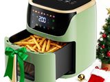 une friteuse à air chaud contenant des frites, à côté d'un sapin de Noël