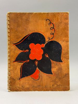 un vieux livre orné d'une fleur, posé sur une table