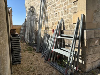 a lot of ladders leaning up against a wall