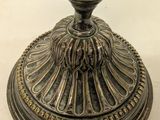 a metal candle holder with a candle on top of it