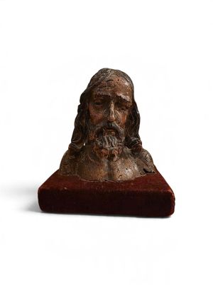 un vieux buste en bronze représentant un homme aux cheveux longs et à la barbe fournie